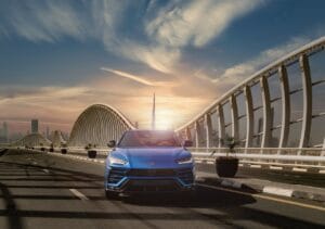 SUV car hire on the road from Abu Dhabi to Dubai with Burj Khalifa view